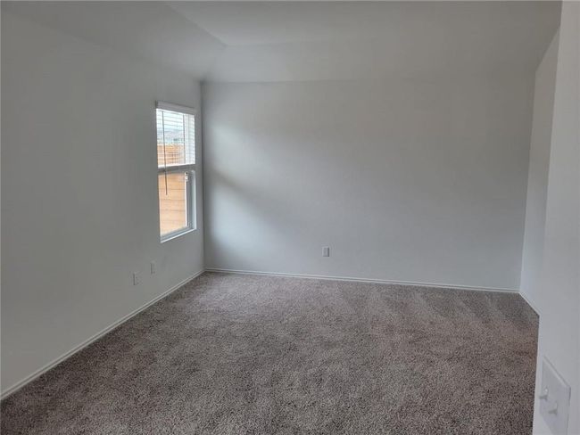Carpeted spare room featuring baseboards and vaulted ceiling | Image 26