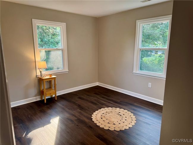 Spare room with healthy amount of natural light, dark wood-style flooring, and baseboards | Image 15