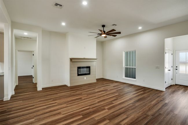 Unfurnished living room featuring recessed lighting, a glass covered fireplace, visible vents, and ceiling fan | Image 6