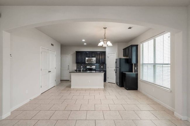 View of dining area and kitchen. Laundry closet to the left. | Image 14