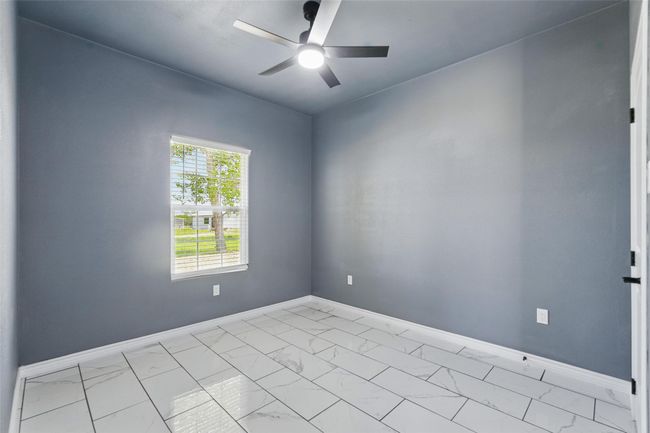 Spare room featuring baseboards, a ceiling fan, and marble finish floor | Image 19