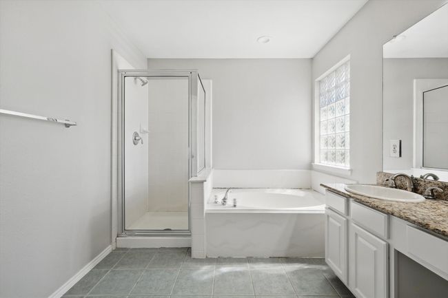 Full bath featuring a shower stall, tile patterned floors, a garden tub, and vanity | Image 18