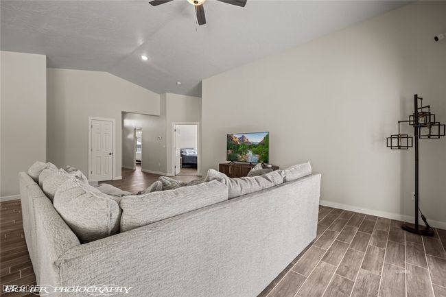 Living room featuring ceiling fan, wood finished floors, baseboards, high vaulted ceiling, and recessed lighting | Image 21