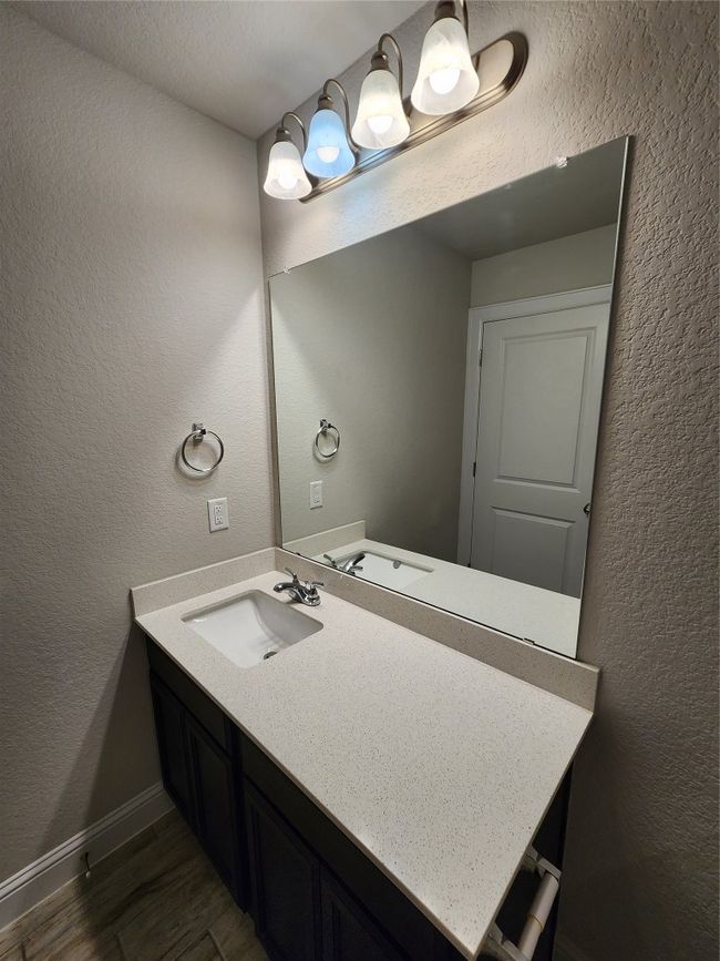 Bathroom featuring wood finished floors, vanity, and a textured wall | Image 18