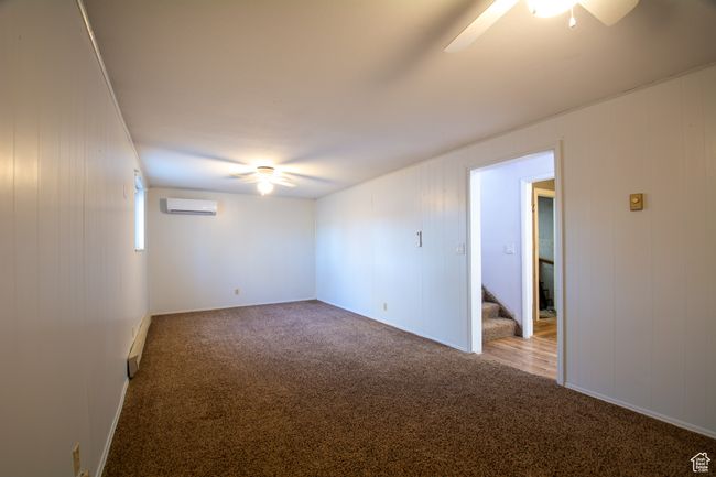 Carpeted living room with ceiling fan and a wall mounted air conditioner | Image 11