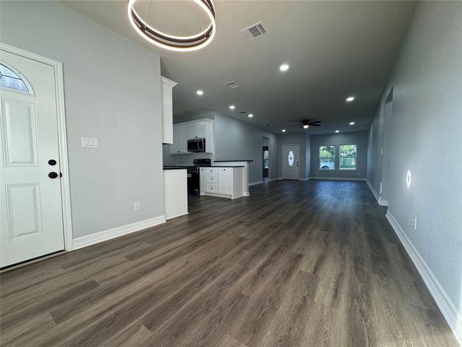 Unfurnished living room with dark wood-type flooring, ceiling fan, and recessed lighting | Image 7