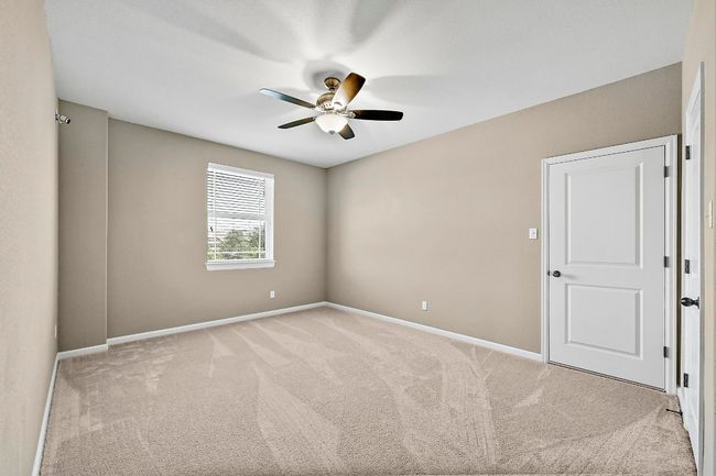 Carpeted bed room with a ceiling fan and baseboards | Image 27