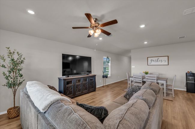 Living room with a ceiling fan, light wood-type flooring, baseboards, and recessed lighting | Image 15