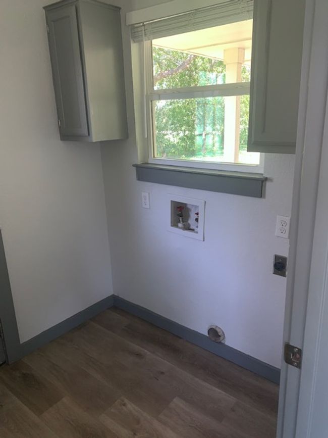 Washroom featuring cabinet space, washer hookup, dark wood-style flooring, and hookup for an electric dryer | Image 14