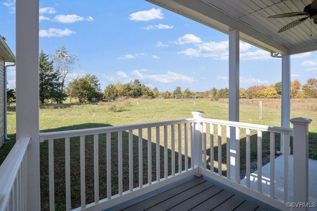 Wooden terrace with a rural view, a ceiling fan, and a lawn | Image 44