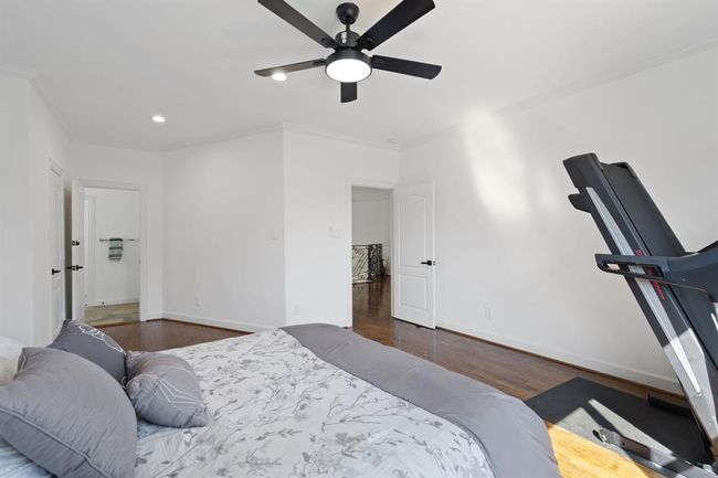 Another view of the secondary bedroom with hardwood flooring, an oversized window, and a ceiling fan that adds comfort to the space. | Image 43