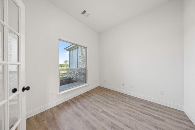 Unfurnished room featuring wood finished floors, baseboards, and lofted ceiling | Image 5