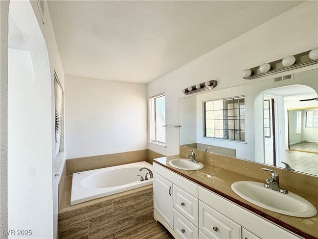 Bathroom featuring double vanity, a relaxing tub, and a textured ceiling | Image 18