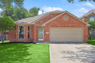 View of front of property featuring a garage and a front lawn | Image 1