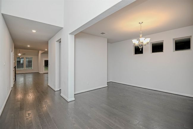 Spare room featuring dark wood-type flooring, baseboards, and visible vents | Image 23