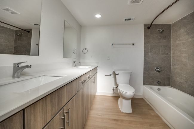 Full bathroom with vanity, toilet, hardwood / wood-style floors, and tiled shower / bath | Image 32