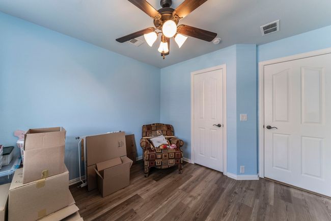 Bedroom with wood finished floors, a desk, baseboards, and ceiling fan | Image 22
