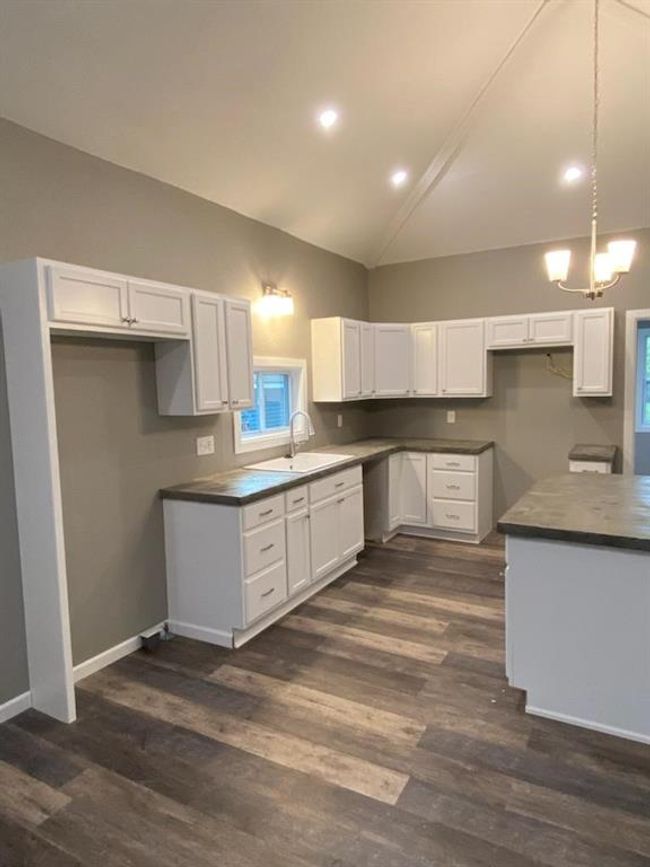 Kitchen with sink, lofted ceiling, white cabinets, and dark hardwood / wood-style floors | Image 14