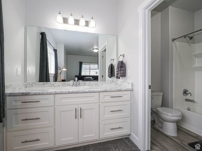 Full bath with washtub / shower combination, wood finished floors, toilet, and vanity | Image 22