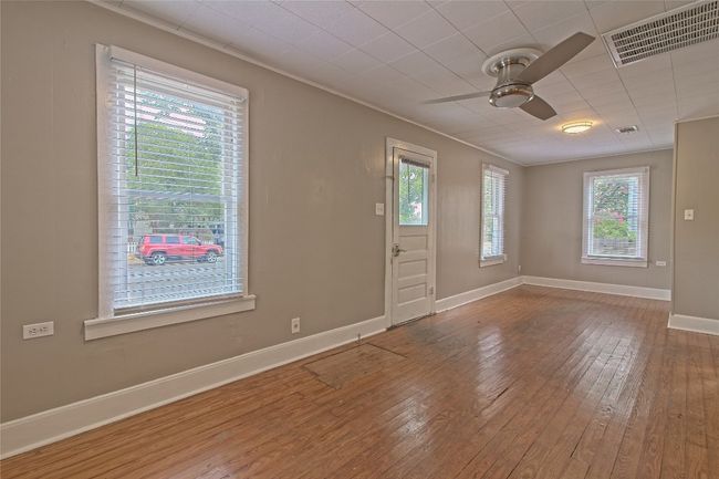Unfurnished room with a ceiling fan, hardwood / wood-style flooring, and crown molding | Image 10