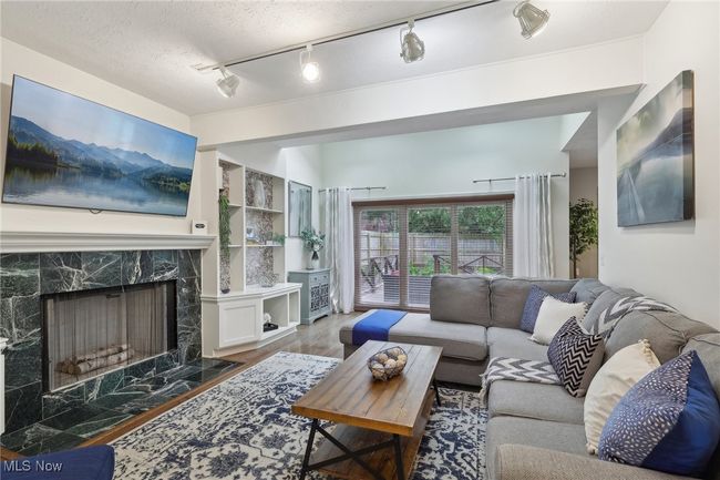 Living area with wood finished floors and a high end fireplace | Image 8