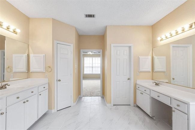 Bathroom with baseboards, two vanities, a sink, and visible vents | Image 17