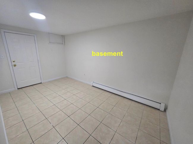Spare room featuring a baseboard heating unit, light tile patterned floors, and baseboards | Image 15