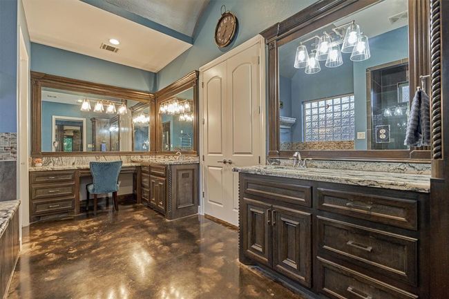 Another view of the dual vanities highlights the framed mirrors, adding a custom, designer touch to the space. A built-in seating area offers a convenient and comfortable spot for getting ready. | Image 30
