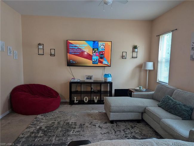 Carpeted living area featuring ceiling fan and baseboards | Image 23
