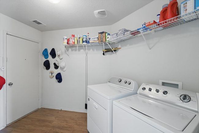 Laundry area with independent washer and dryer, wood finished floors, and a textured ceiling | Image 27