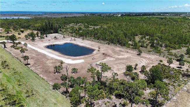 Drone / aerial view of a heavily wooded area and a large body of water | Image 17