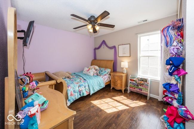 bedroom with wood-type flooring, baseboards, ceiling fan, and visible vents | Image 21