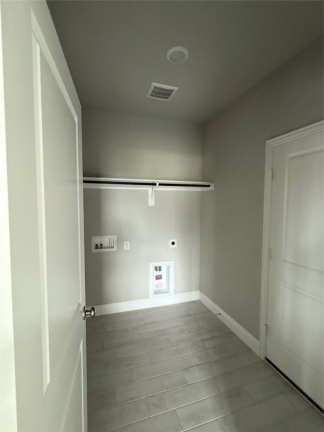 Laundry room featuring hookup for an electric dryer, hookup for a washing machine, and wood finished floors | Image 9