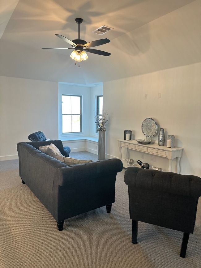 Carpeted living area featuring visible vents, ceiling fan, and baseboards | Image 38
