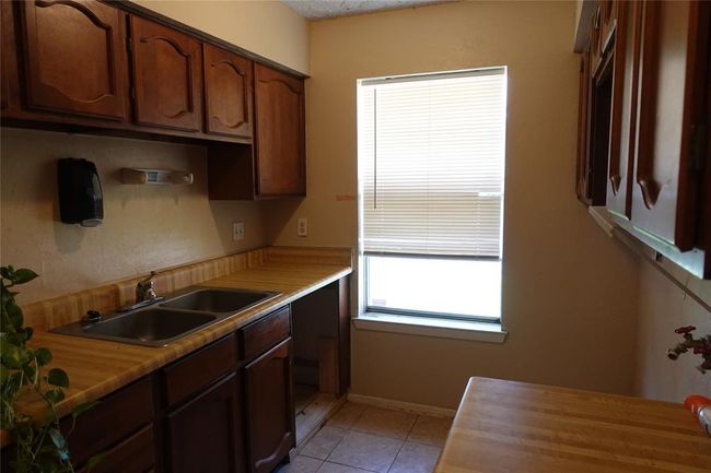 Convenient laundry area featuring a sink and ample cabinet storage. | Image 9