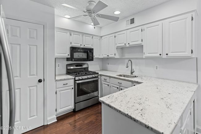 Stylish, sleek modern Kitchen with crisp white cabinetry. | Image 4
