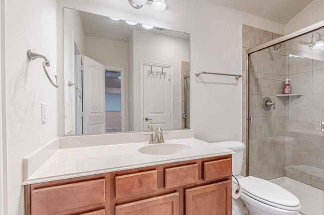 Bathroom with toilet, a stall shower, and vanity | Image 34