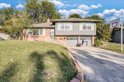 Tri-level home featuring a garage and a front lawn | Image 1