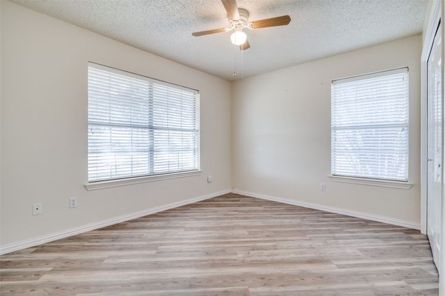 Unfurnished room with ceiling fan, baseboards, light wood-type flooring, and a textured ceiling | Image 22