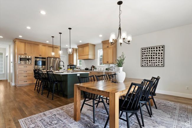 Dining room featuring light wood-type flooring, baseboards, recessed lighting, and a chandelier | Image 9