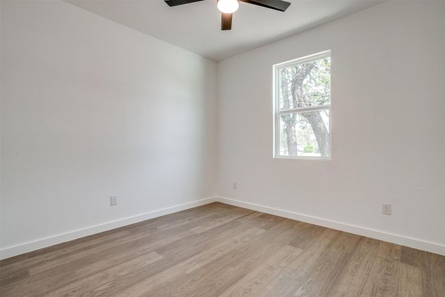 Empty room featuring light wood-type flooring, baseboards, and ceiling fan | Image 29
