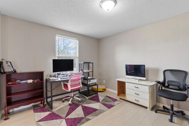 Office space featuring a textured ceiling and light wood-type flooring | Image 5