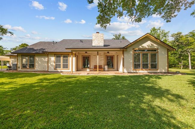 Inviting covered patio, with ceiling fans overhead and a paved terrace perfect for year-round outdoor enjoyment. | Image 34
