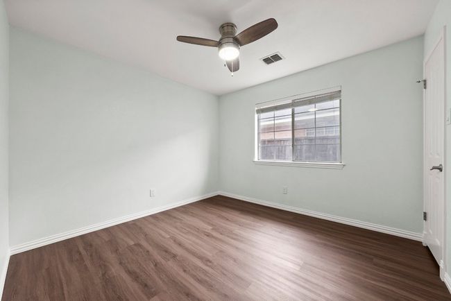 Spare room with wood finished floors, ceiling fan, and baseboards | Image 17
