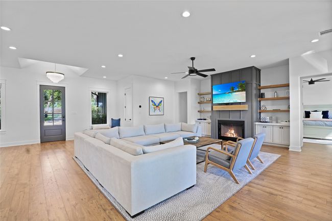 Living area with ceiling fan, light wood-style flooring, a large fireplace, and recessed lighting | Image 10