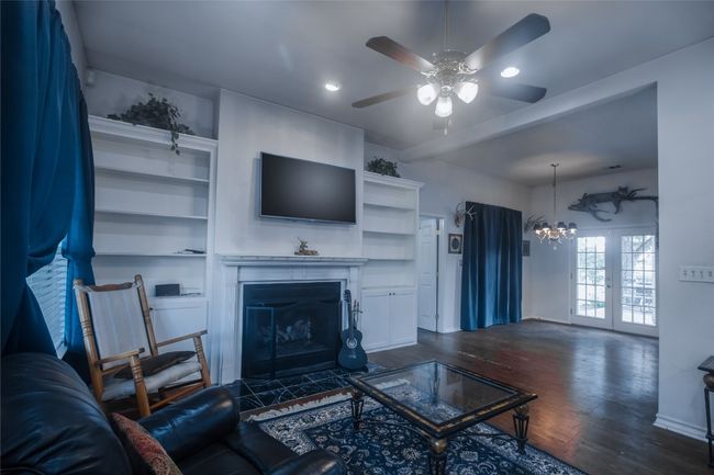 Living area featuring ceiling fan, dark wood finished floors, a chandelier, recessed lighting, and a fireplace with flush hearth | Image 8