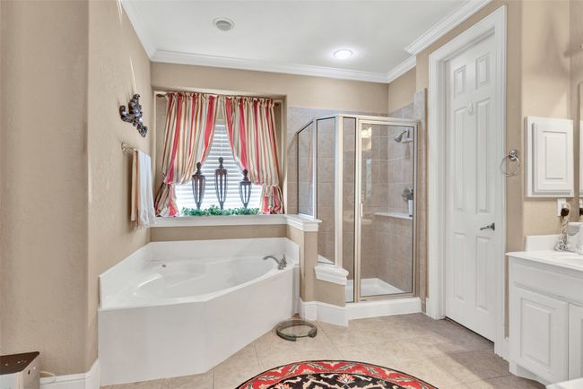 The large soaking tub is nestled under a sunny window for more natural light. | Image 16