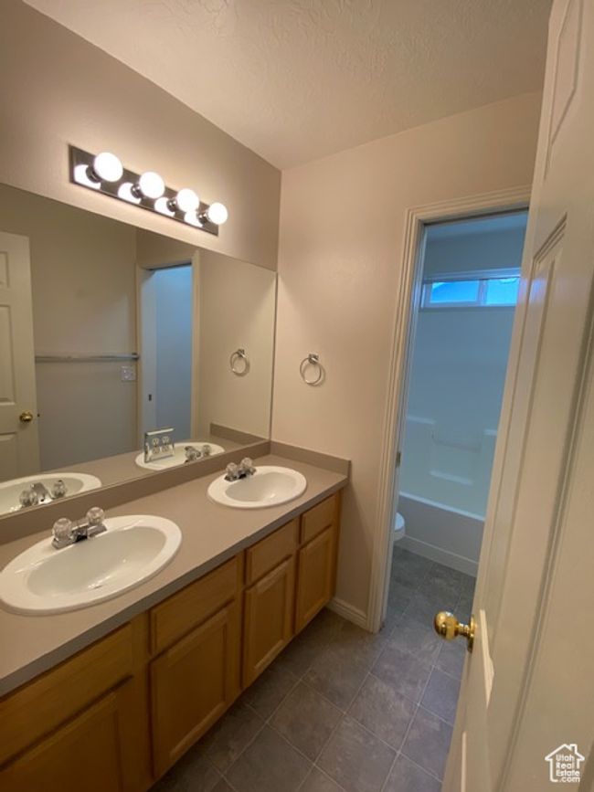 Bathroom featuring double vanity, a sink, toilet, and tile patterned floors | Image 10