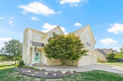 View of property hidden behind natural elements featuring a garage and a front lawn | Image 2