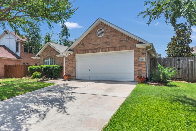 View of front facade featuring concrete driveway, an attached garage, and brick siding | Image 4